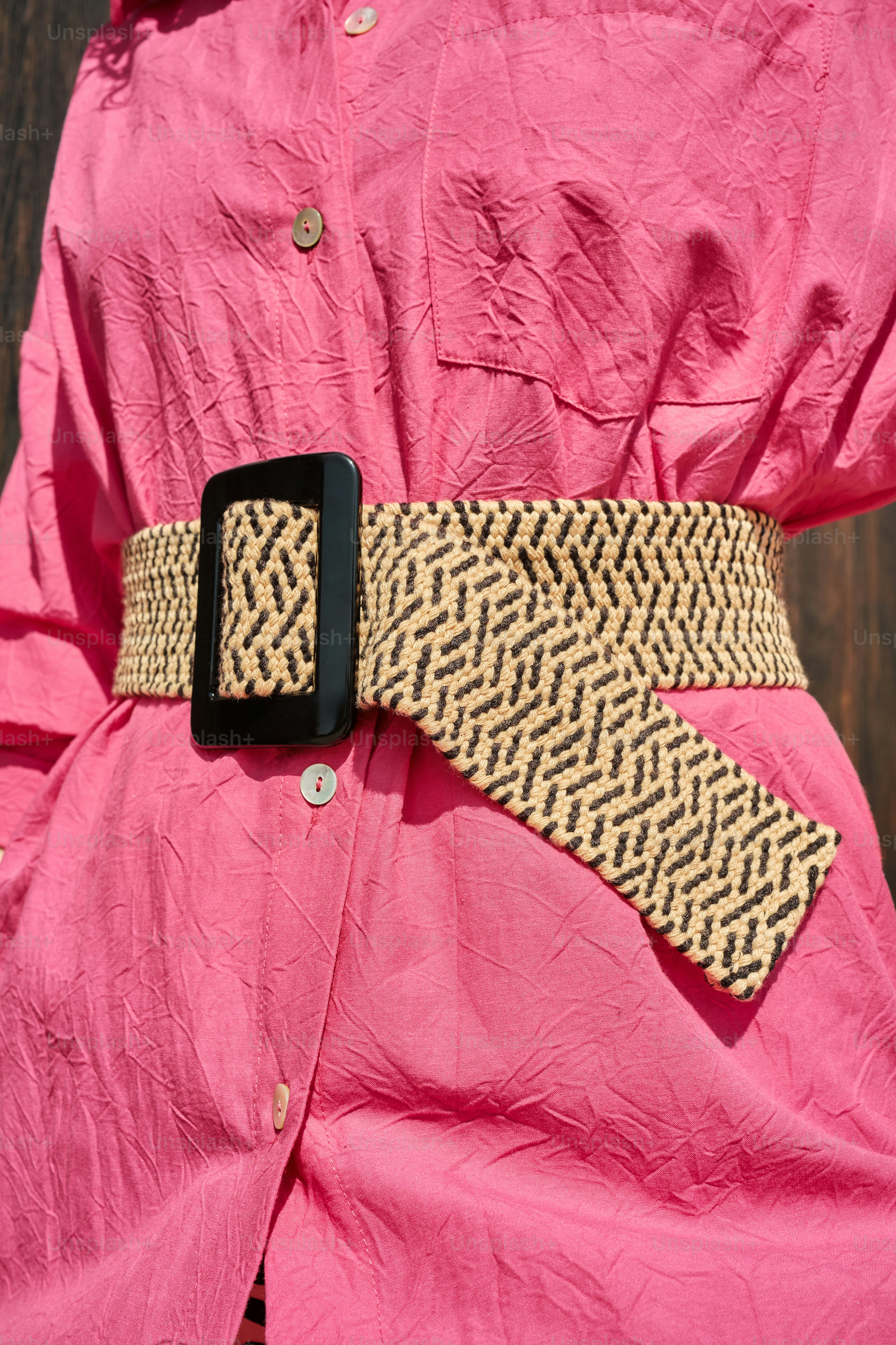 une personne portant une chemise rose et une ceinture