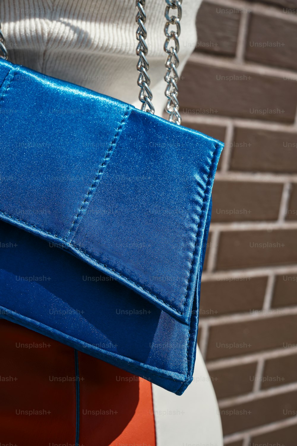 Una mujer sosteniendo un bolso azul sobre su hombro