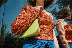 a woman holding a green purse in front of a mirror