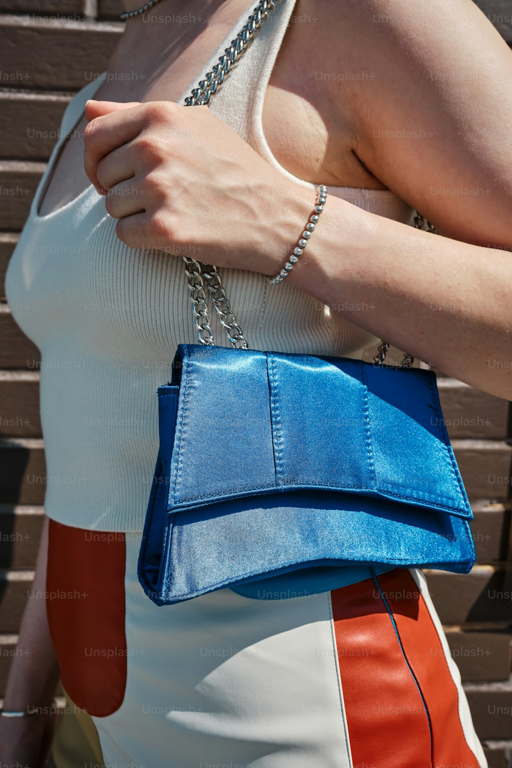 a woman holding a blue purse in her hand