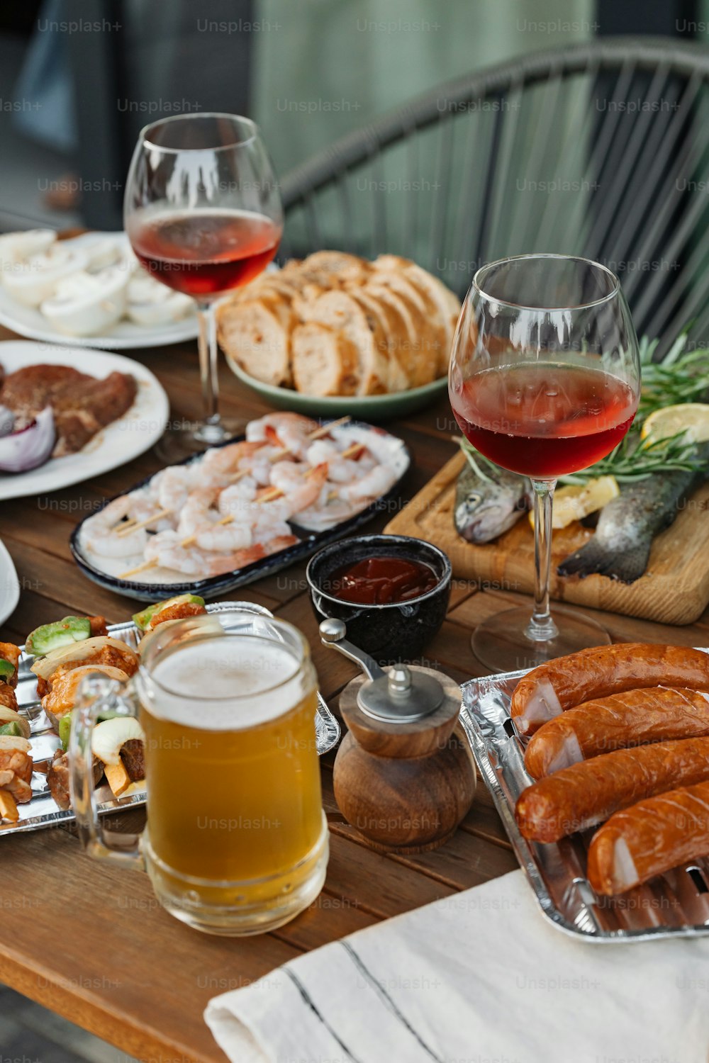 a wooden table topped with plates of food and glasses of wine