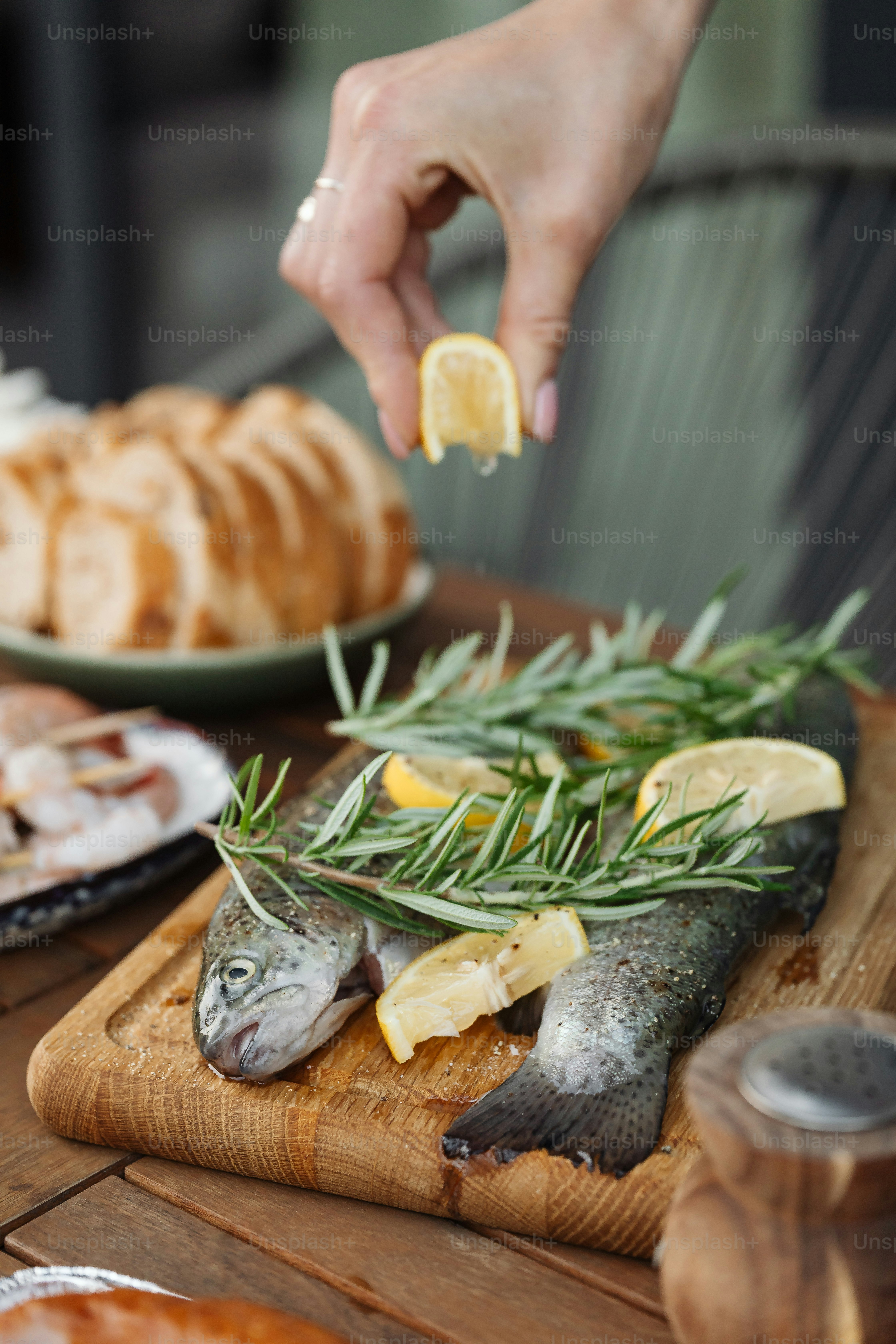 a person is putting a lemon slice on a fish