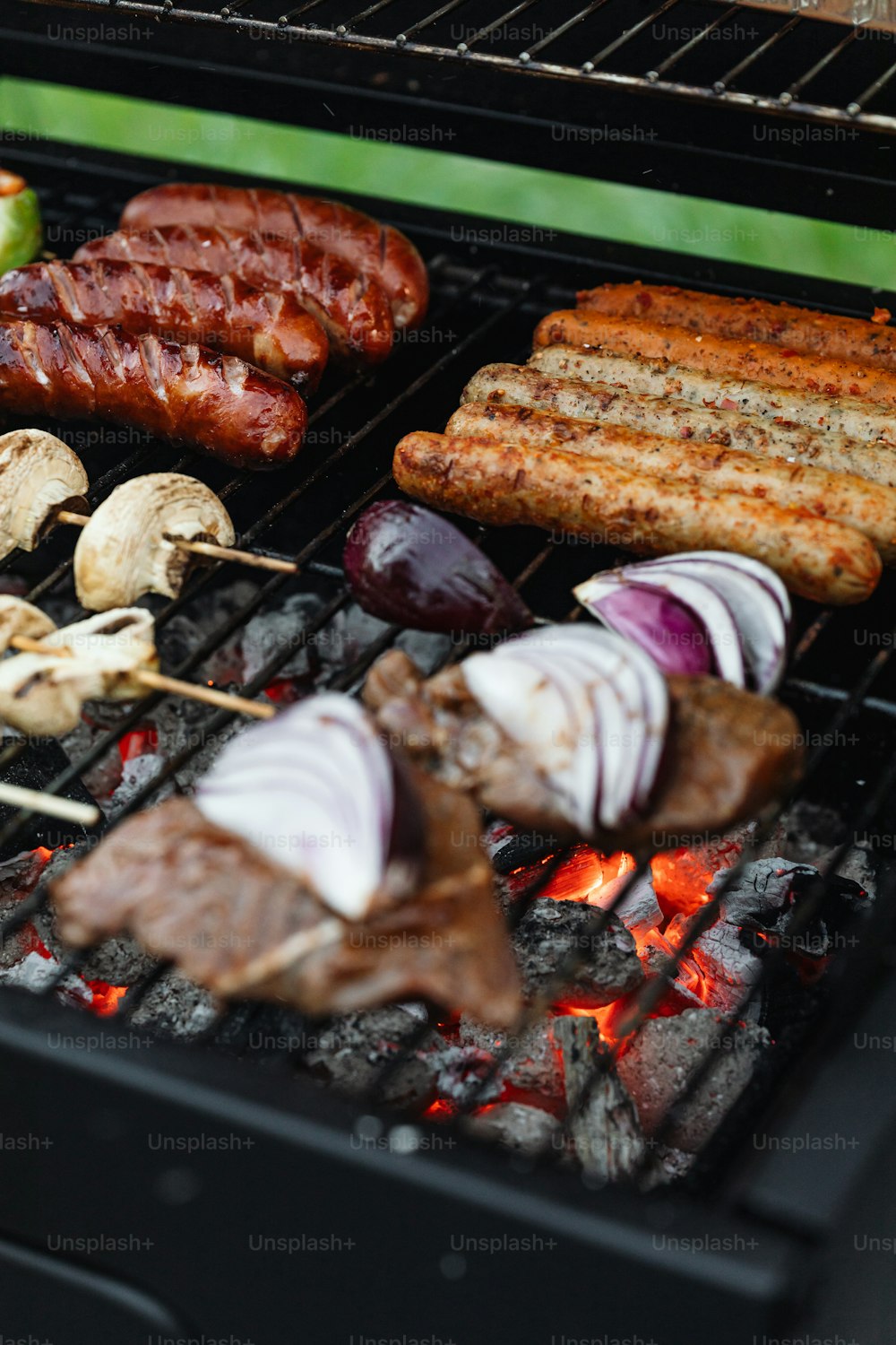 a close up of a grill with meat and vegetables on it
