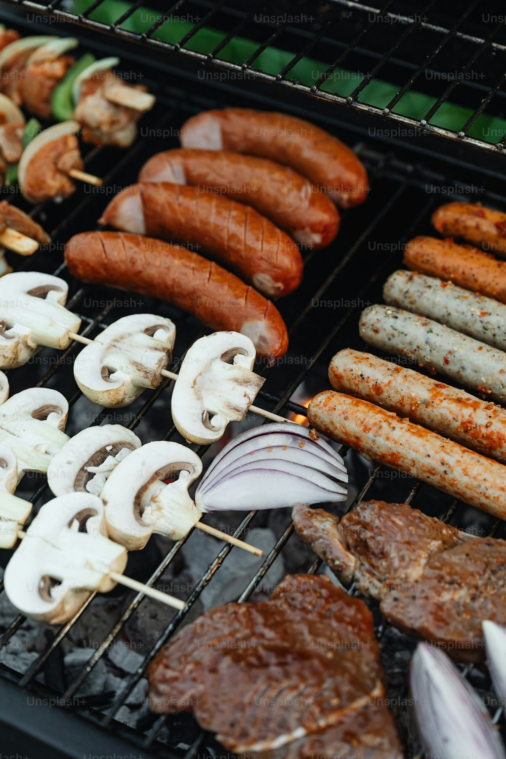 sausages, mushrooms, and mushrooms are cooking on a grill