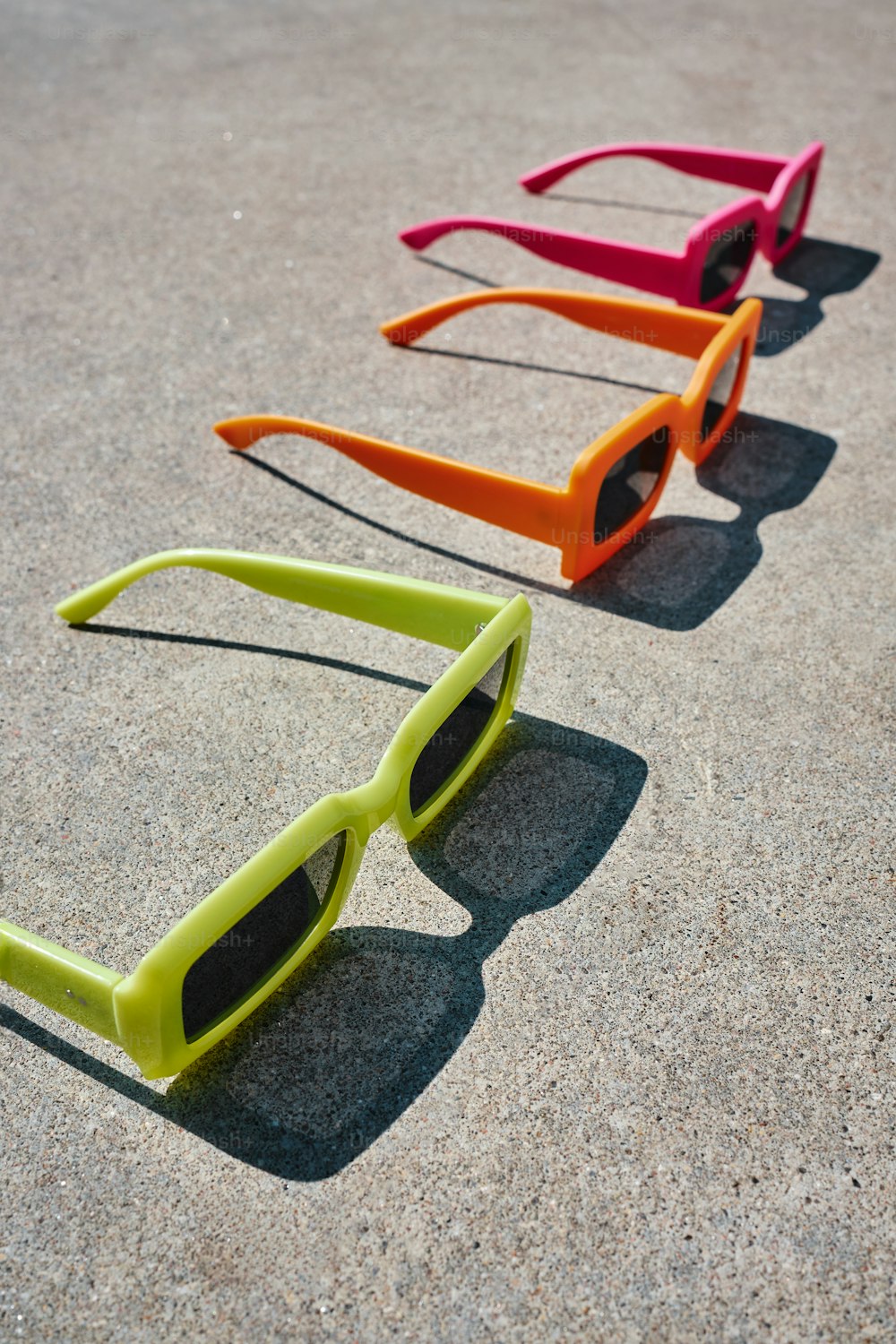 Drei Sonnenbrillen sitzen auf dem Boden