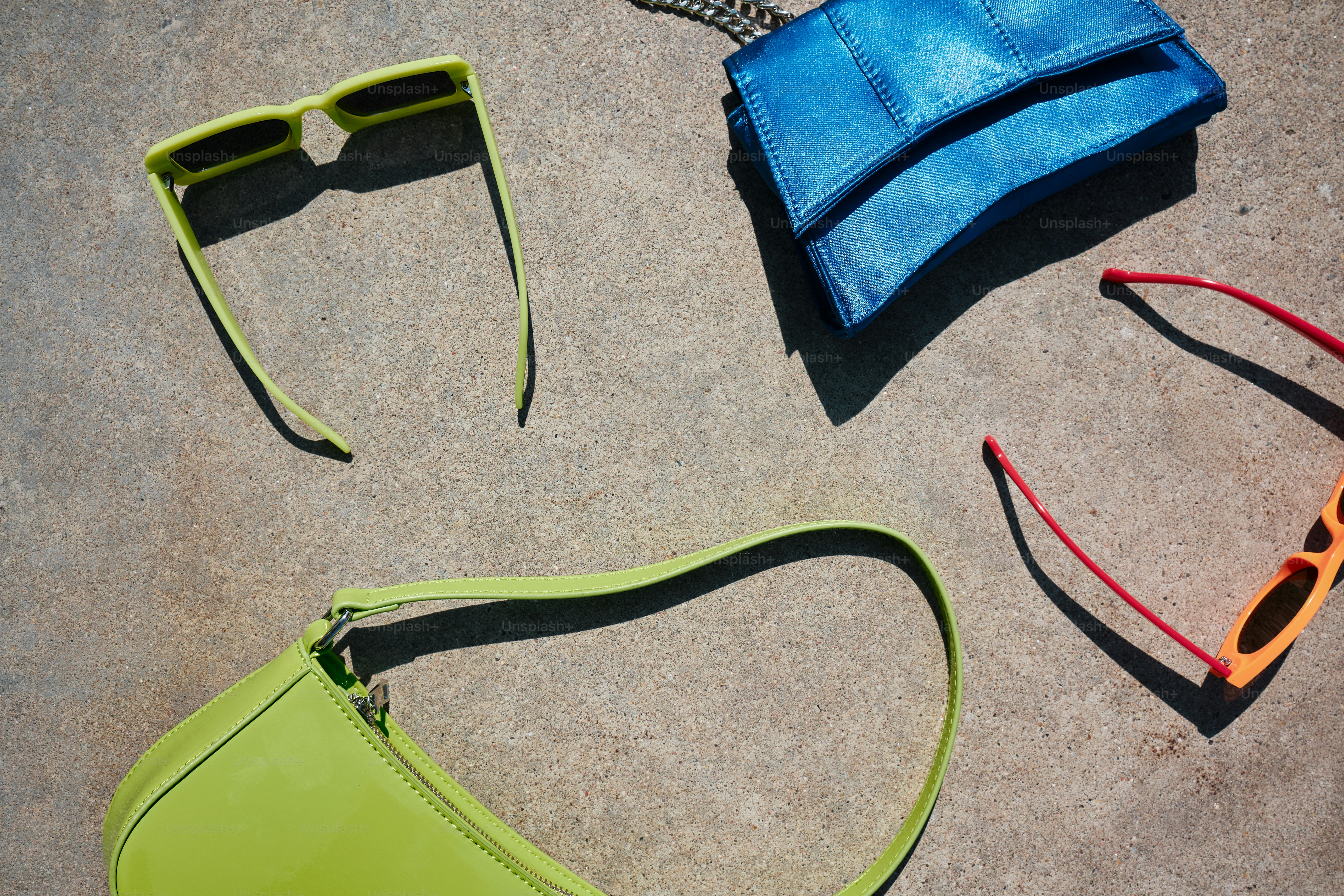 a pair of sunglasses and a purse laying on the ground