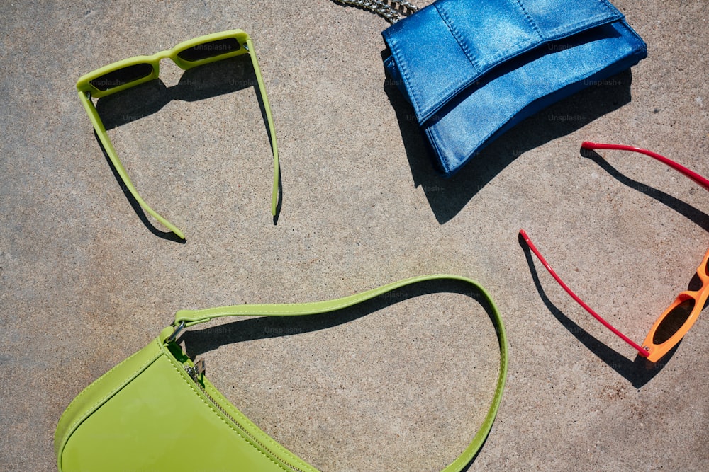 une paire de lunettes de soleil et un sac à main posé sur le sol