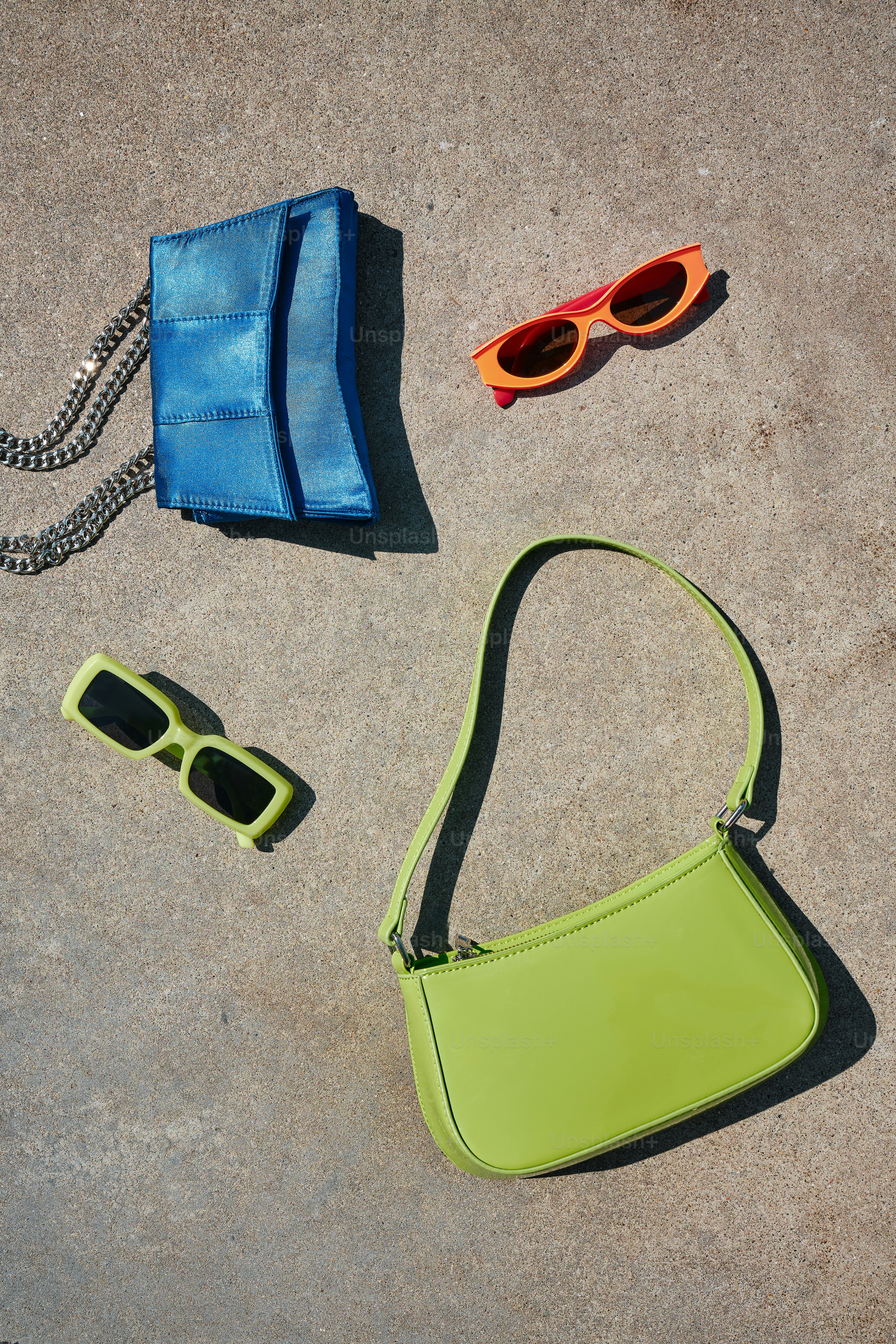 a purse, sunglasses, and a purse laying on the ground