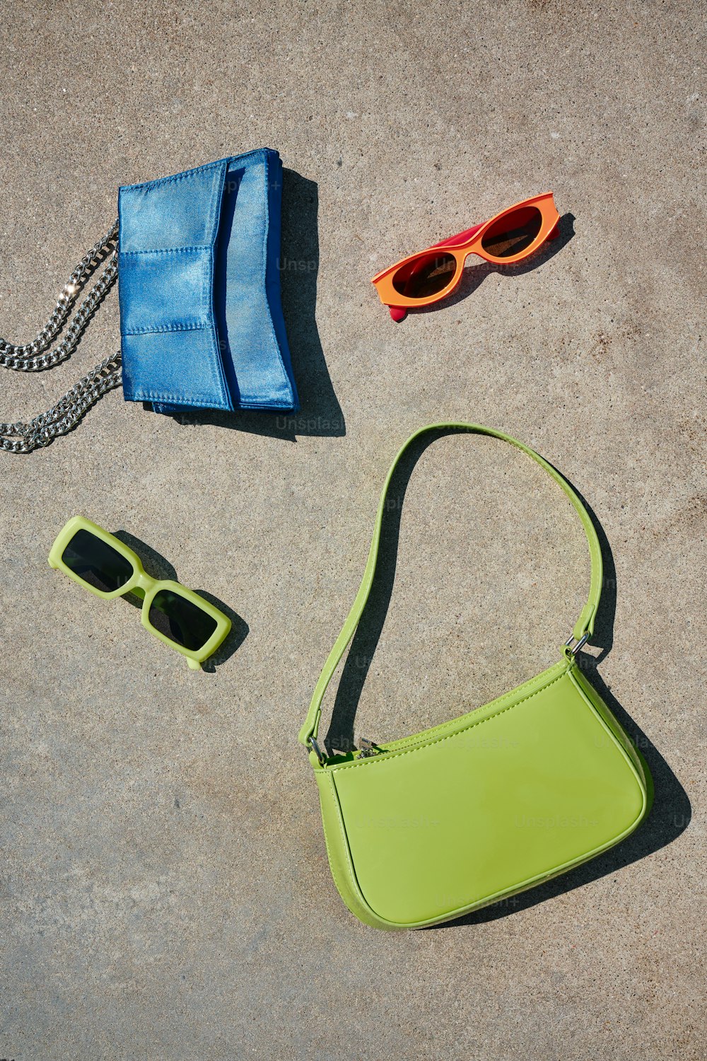a purse, sunglasses, and a purse laying on the ground