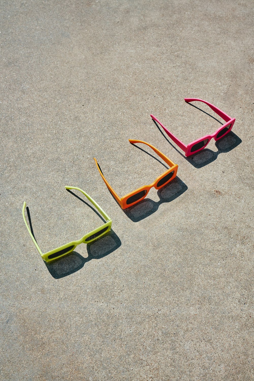 three pairs of glasses laying on the ground