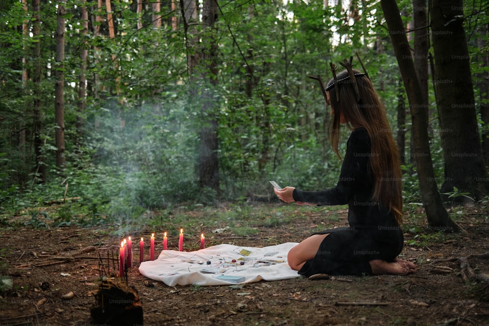 숲 속에서 담요를 덮고 앉아 있는 여자