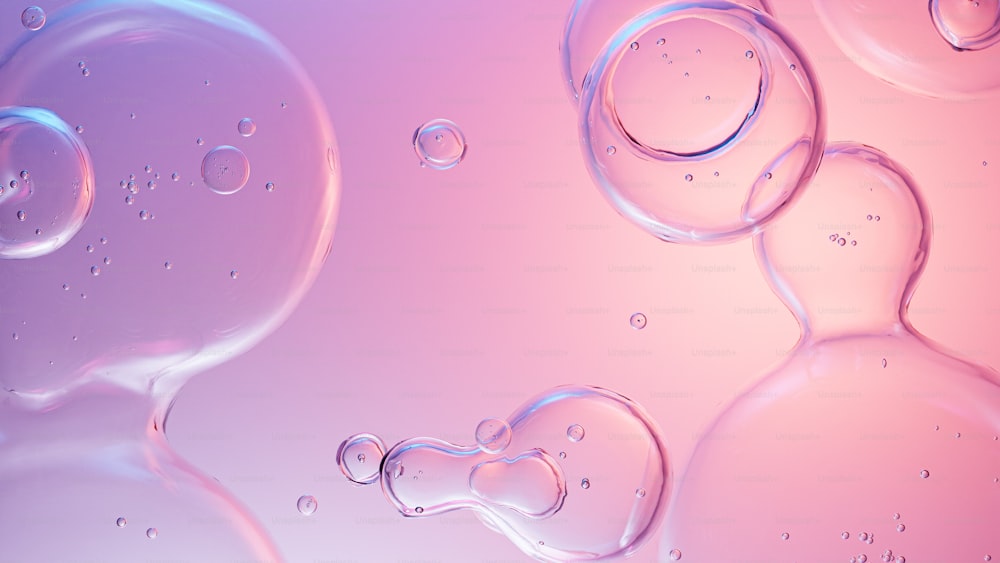 a close up of water bubbles on a pink background
