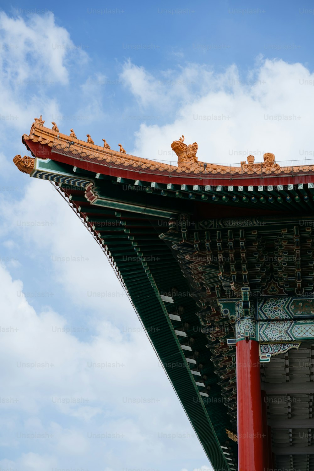 a tall red and green building with a sky in the background