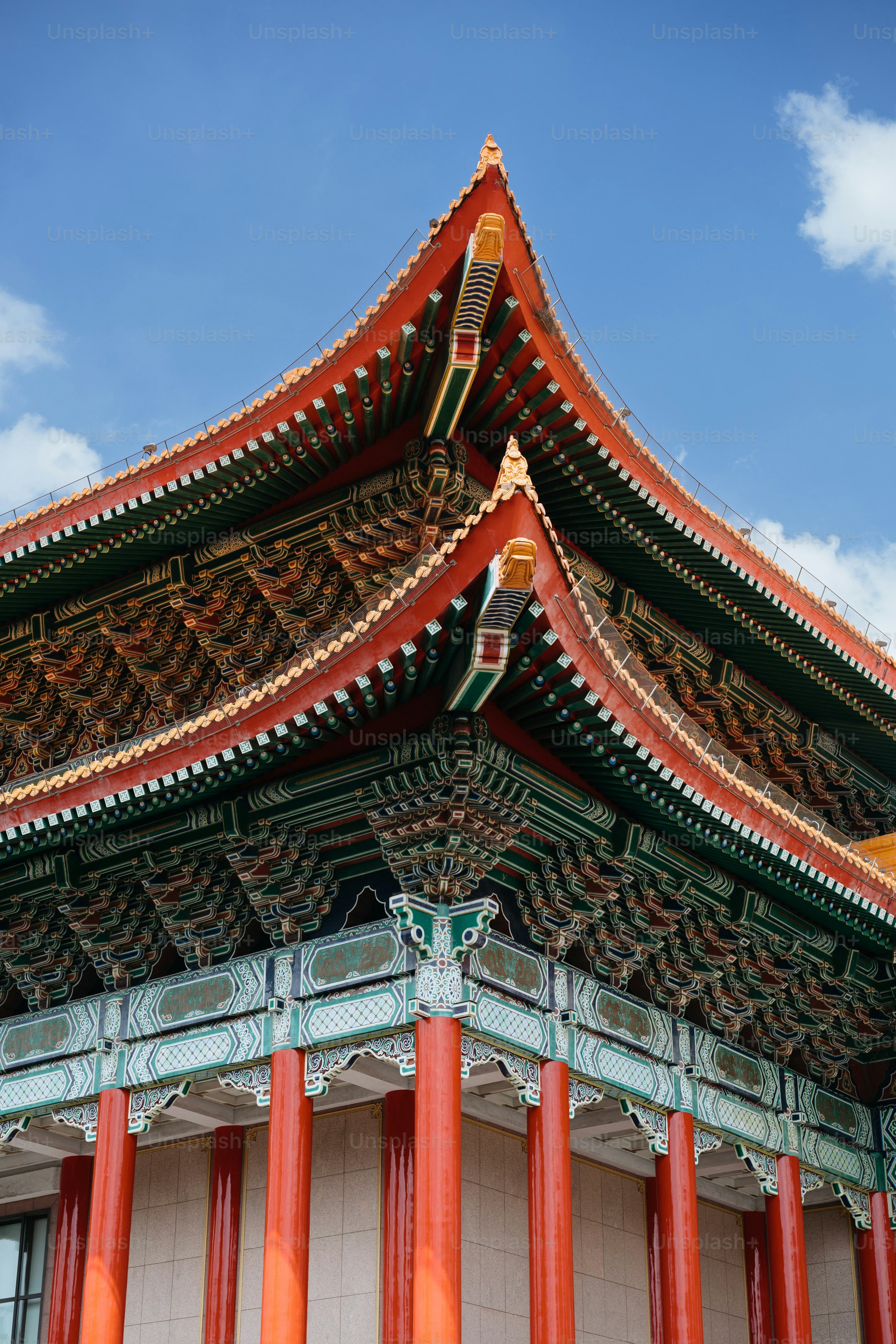 Un edificio alto con pilares rojos y un cielo azul en el fondo