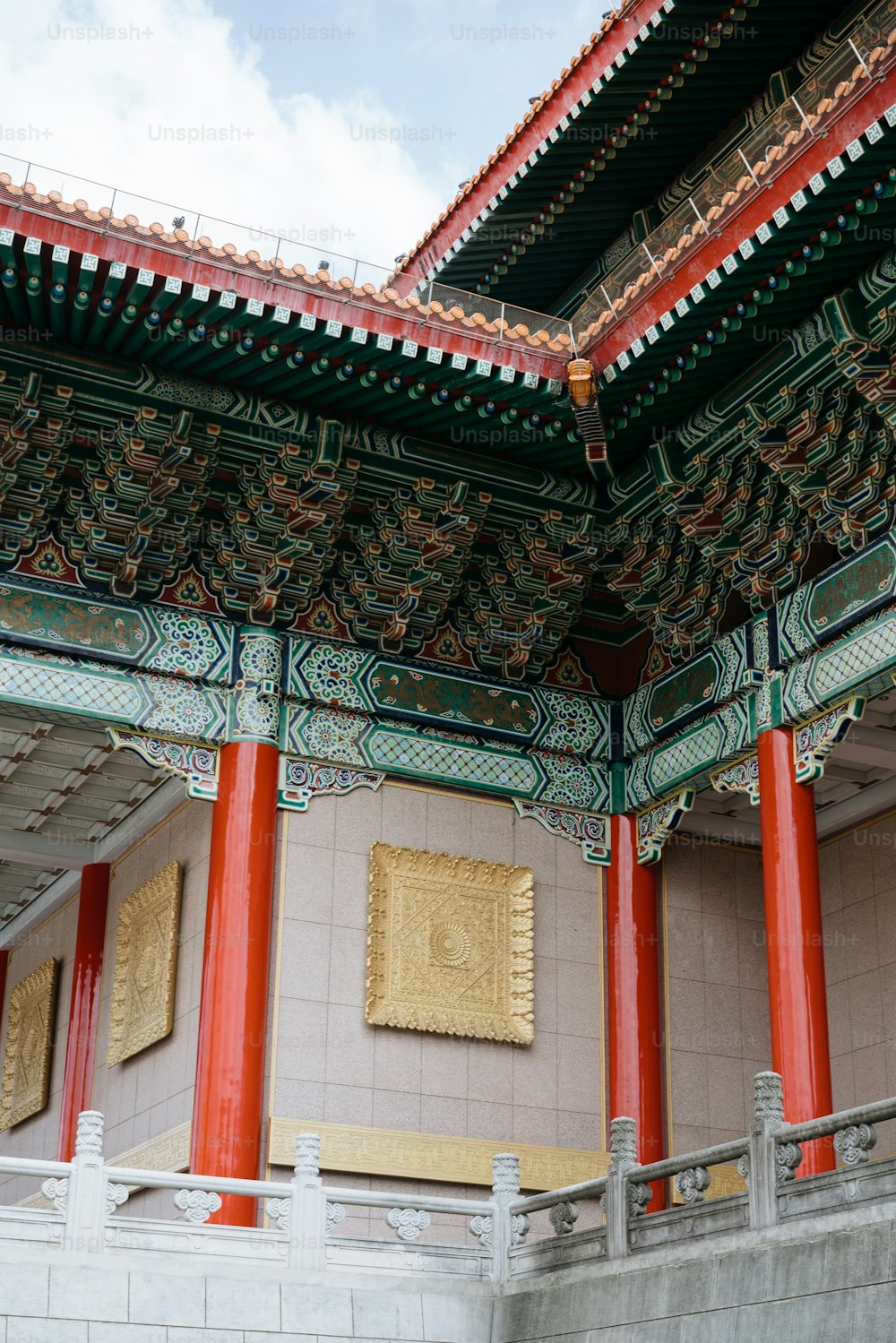 a building with red and green columns and a clock