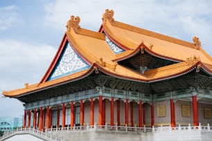 um edifício com um telhado dourado e pilares vermelhos