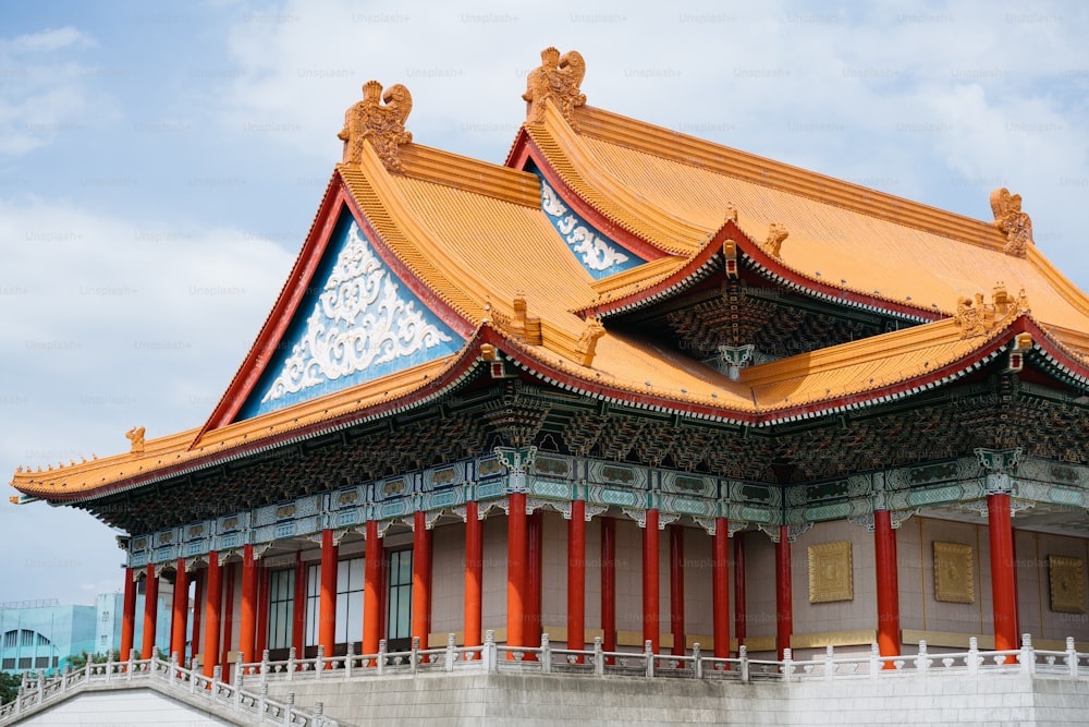 a building with a golden roof and red pillars