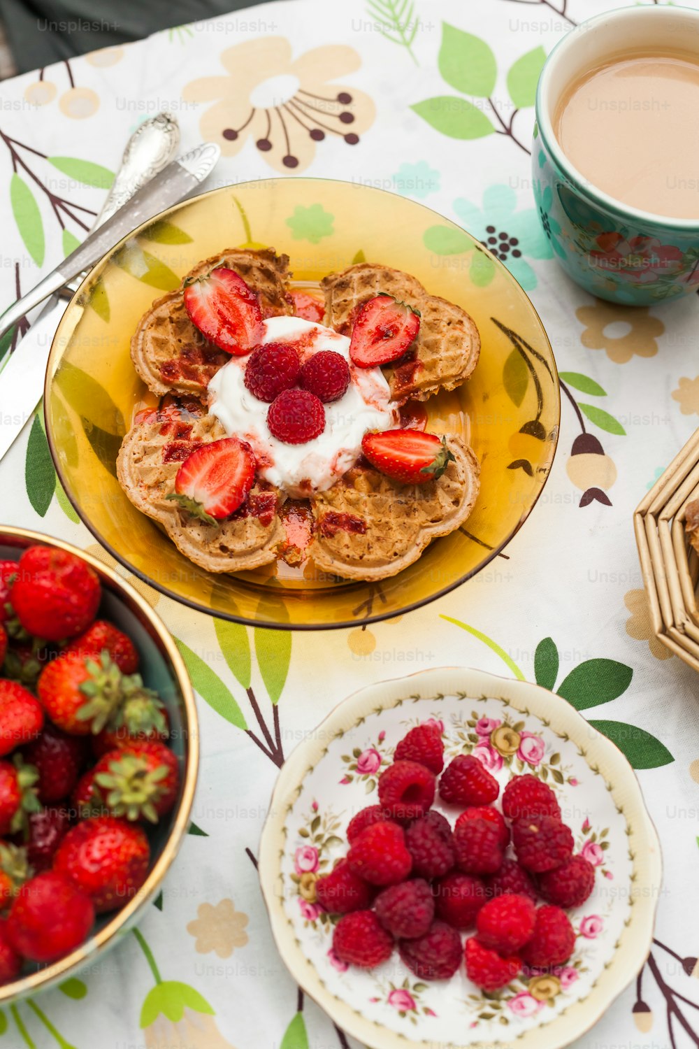 a table topped with plates of food and cups of coffee