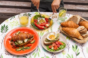 a table topped with plates of food and croissants