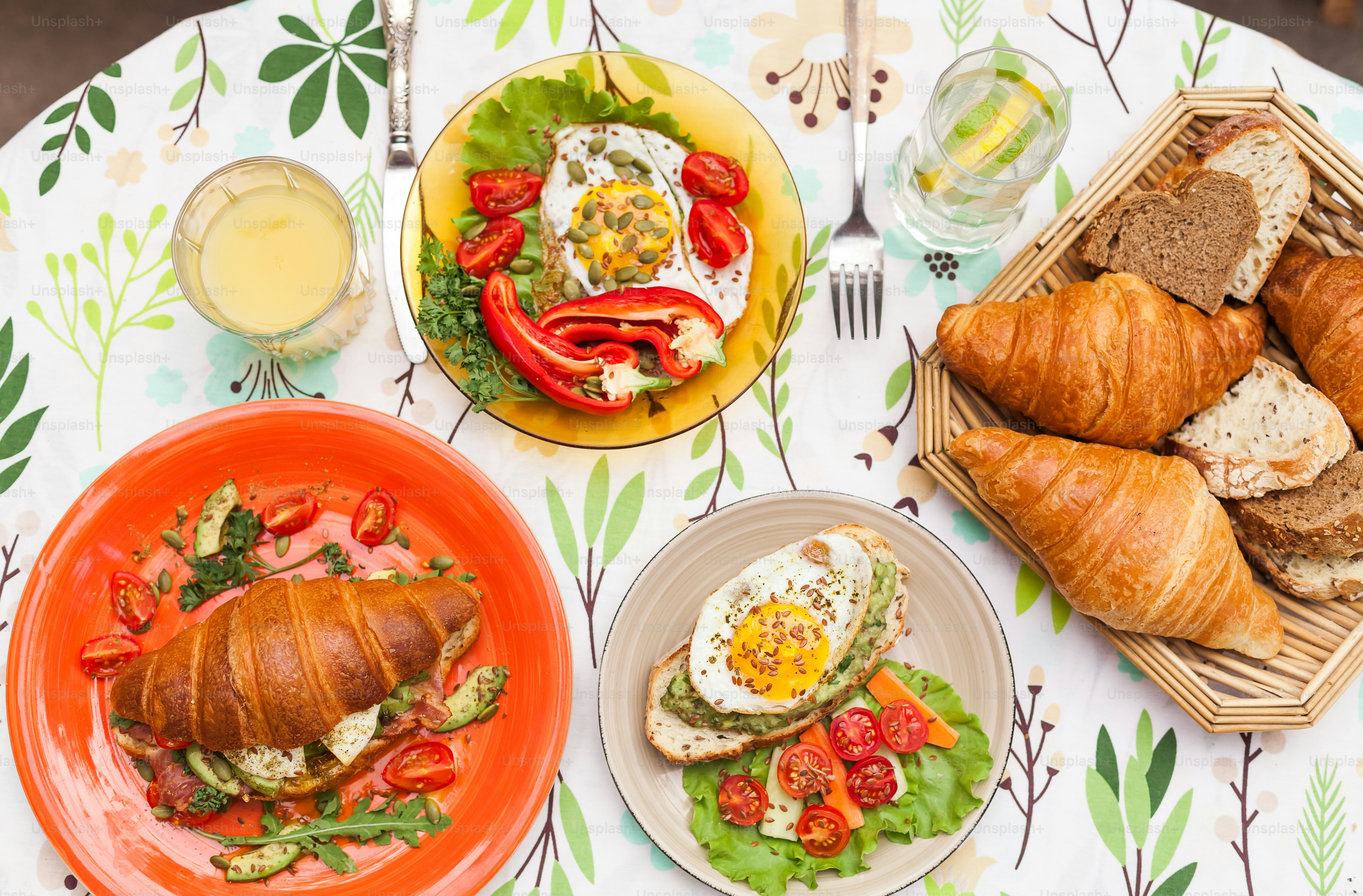 A table topped with plates of food and croissants photo – Croissant ...
