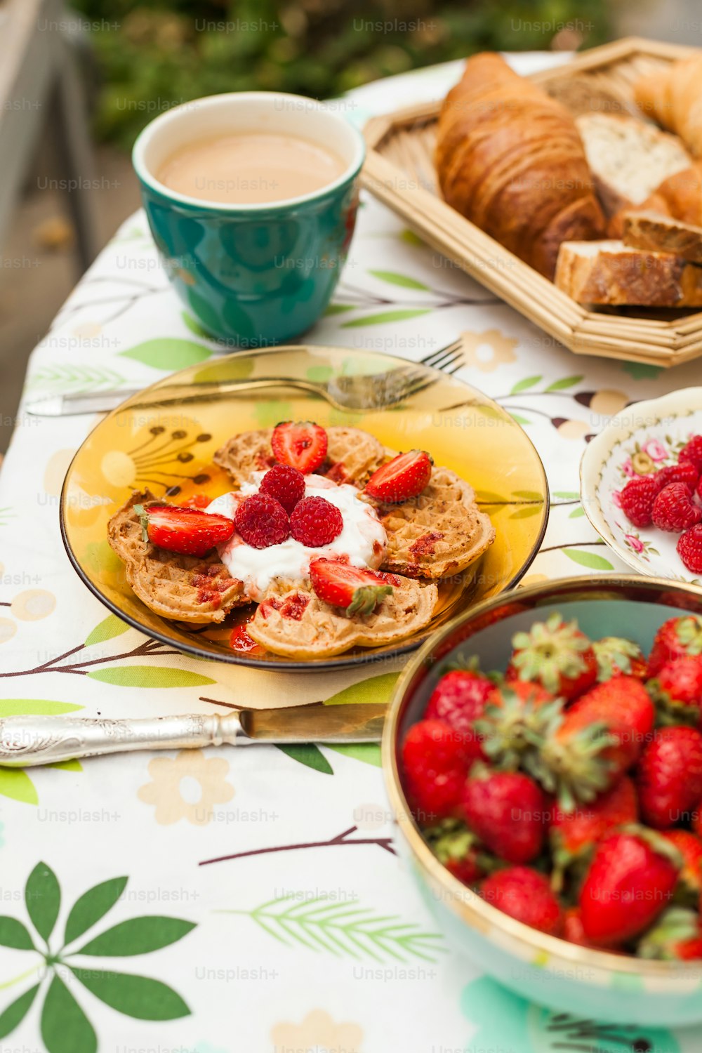a table topped with plates of food and bowls of strawberries