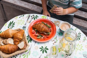 a table topped with a plate of food and croissants