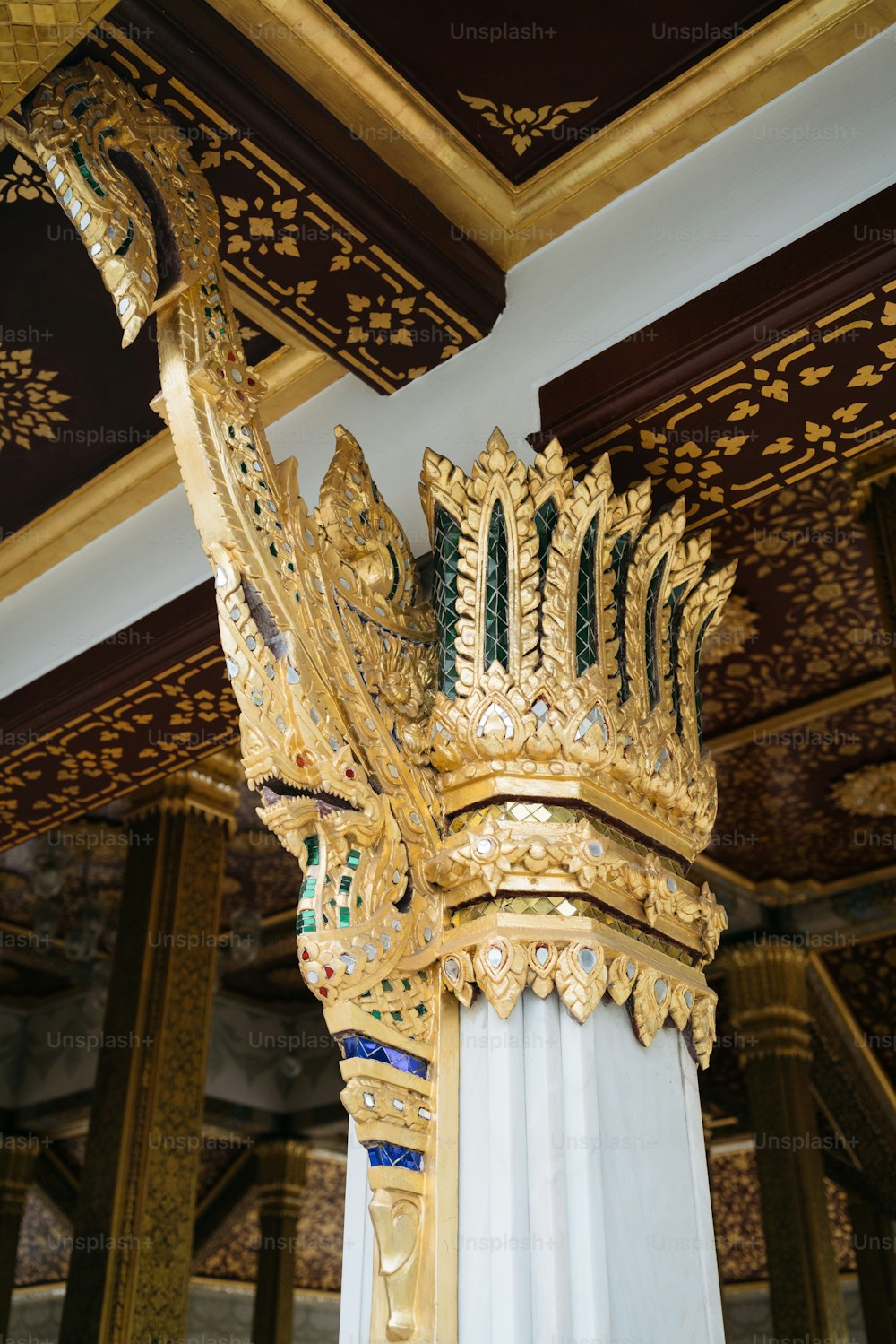 그 위에 왕관이 있는 금색과 흰색 기둥