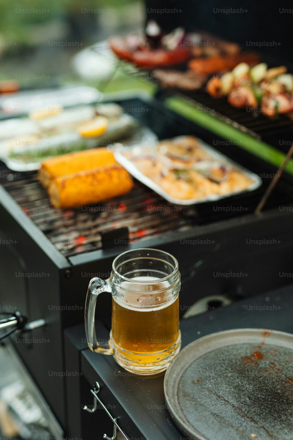 a glass of beer sitting on top of a grill