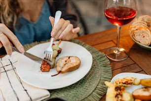 a woman is cutting a piece of bread with a knife and fork