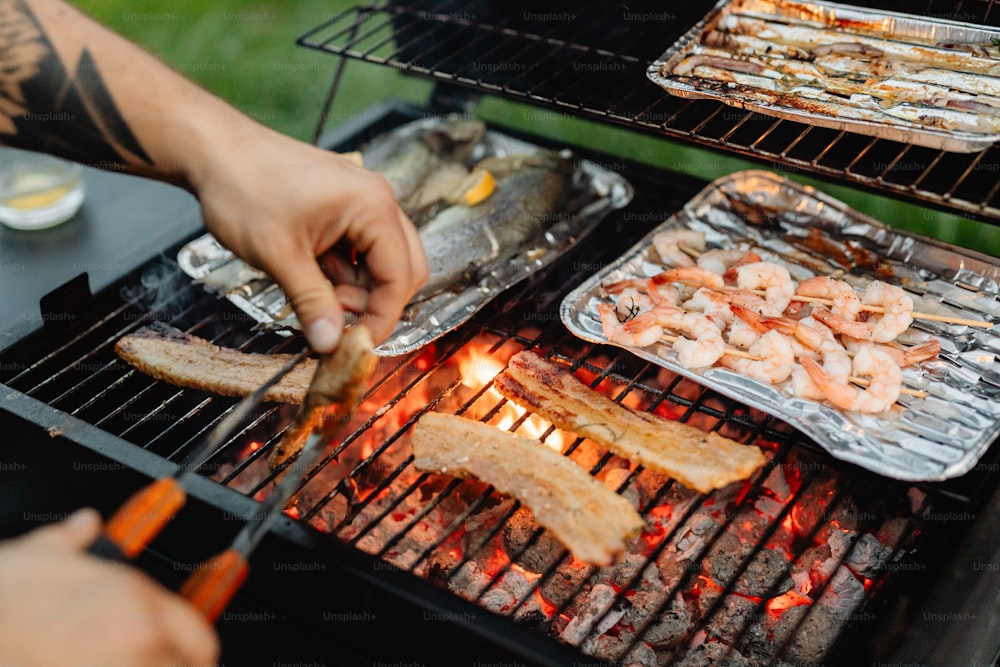 a man grilling shrimp and shrimp on a grill