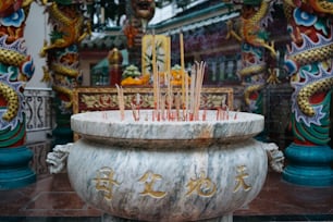 Palitos de incenso são colocados em uma tigela de mármore