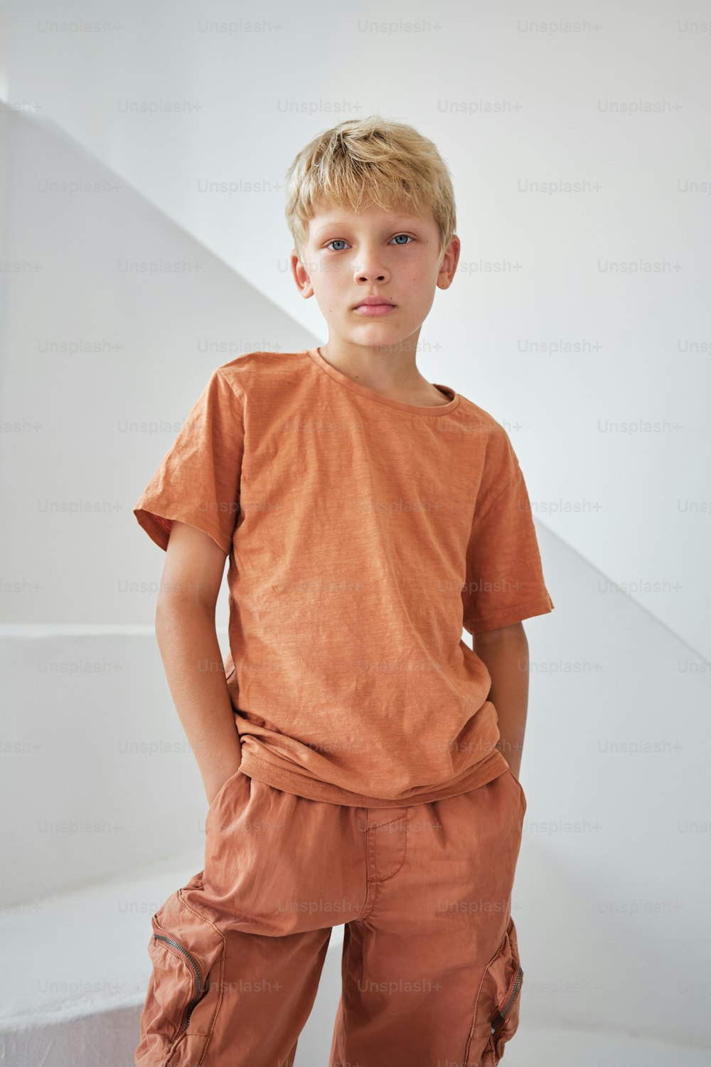 a young boy standing in front of a staircase