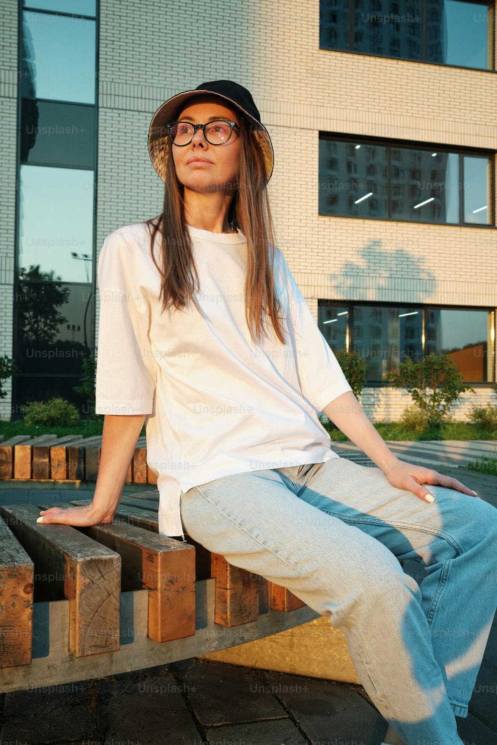 a woman sitting on top of a wooden bench