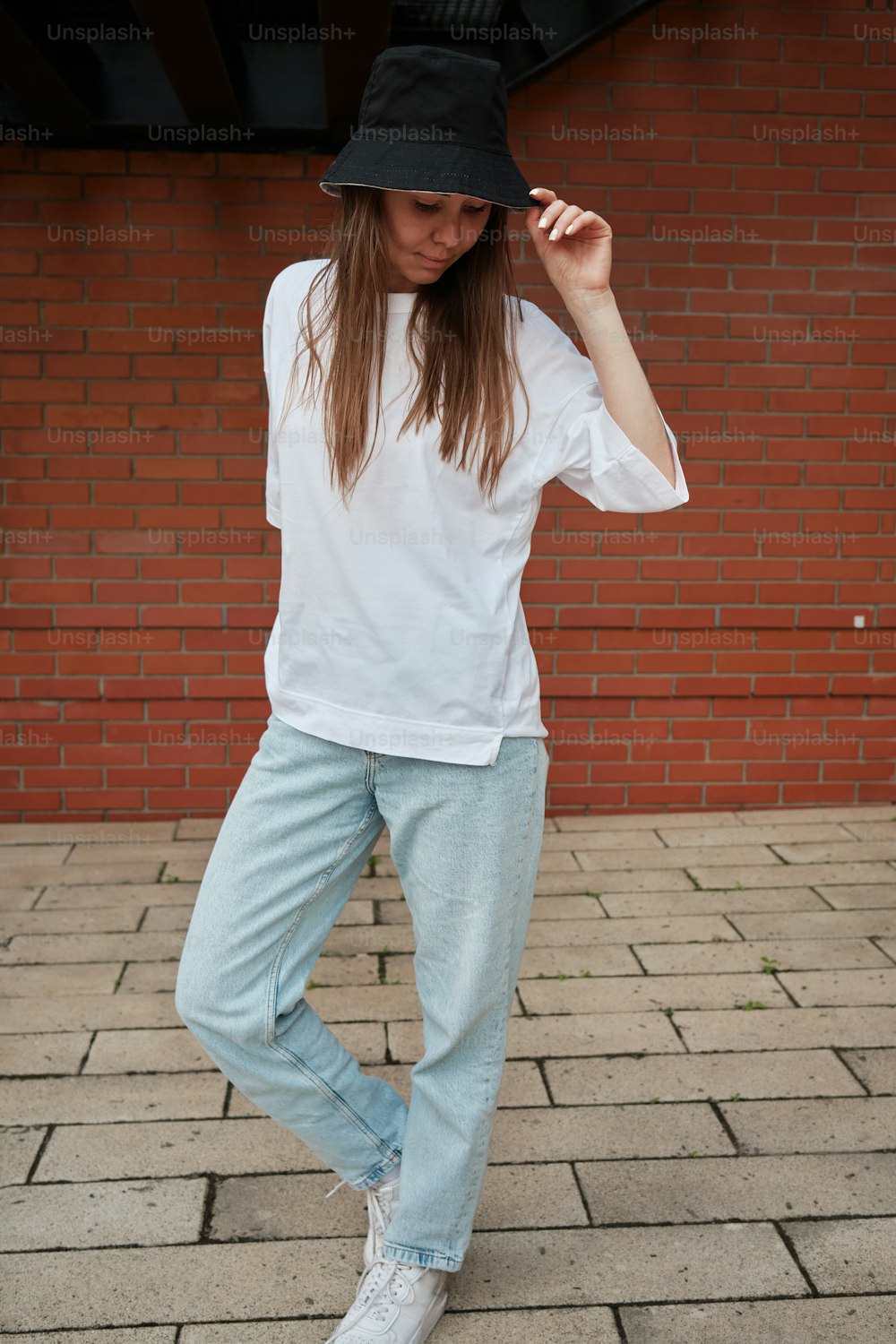 a woman wearing a hat and blue jeans