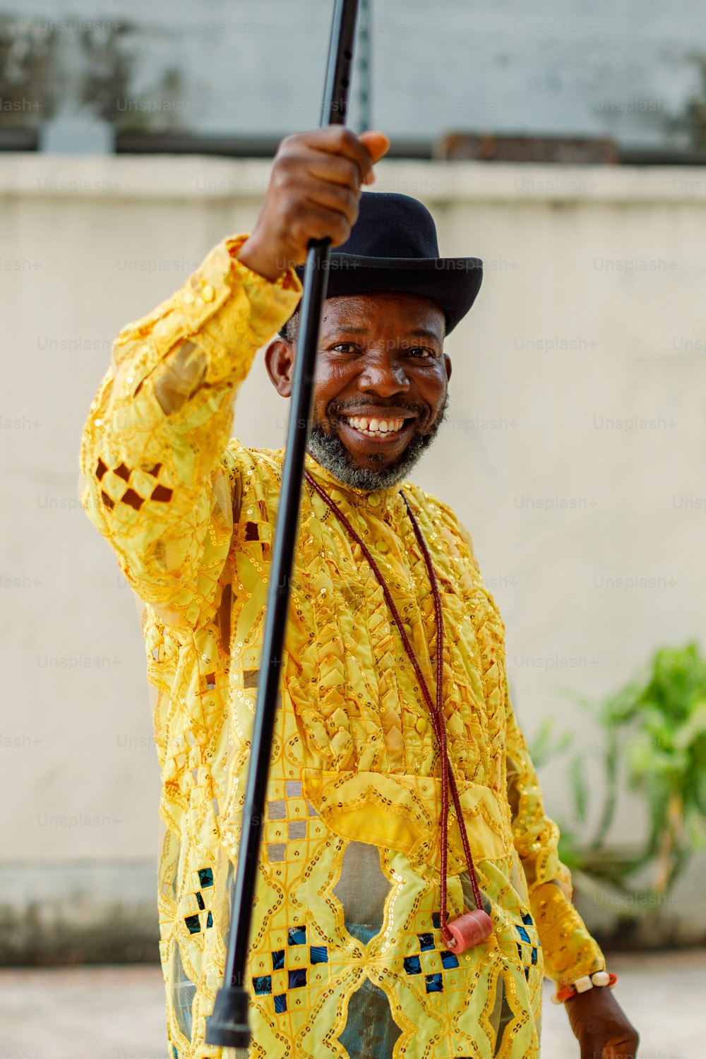 a man in a yellow shirt holding a black umbrella