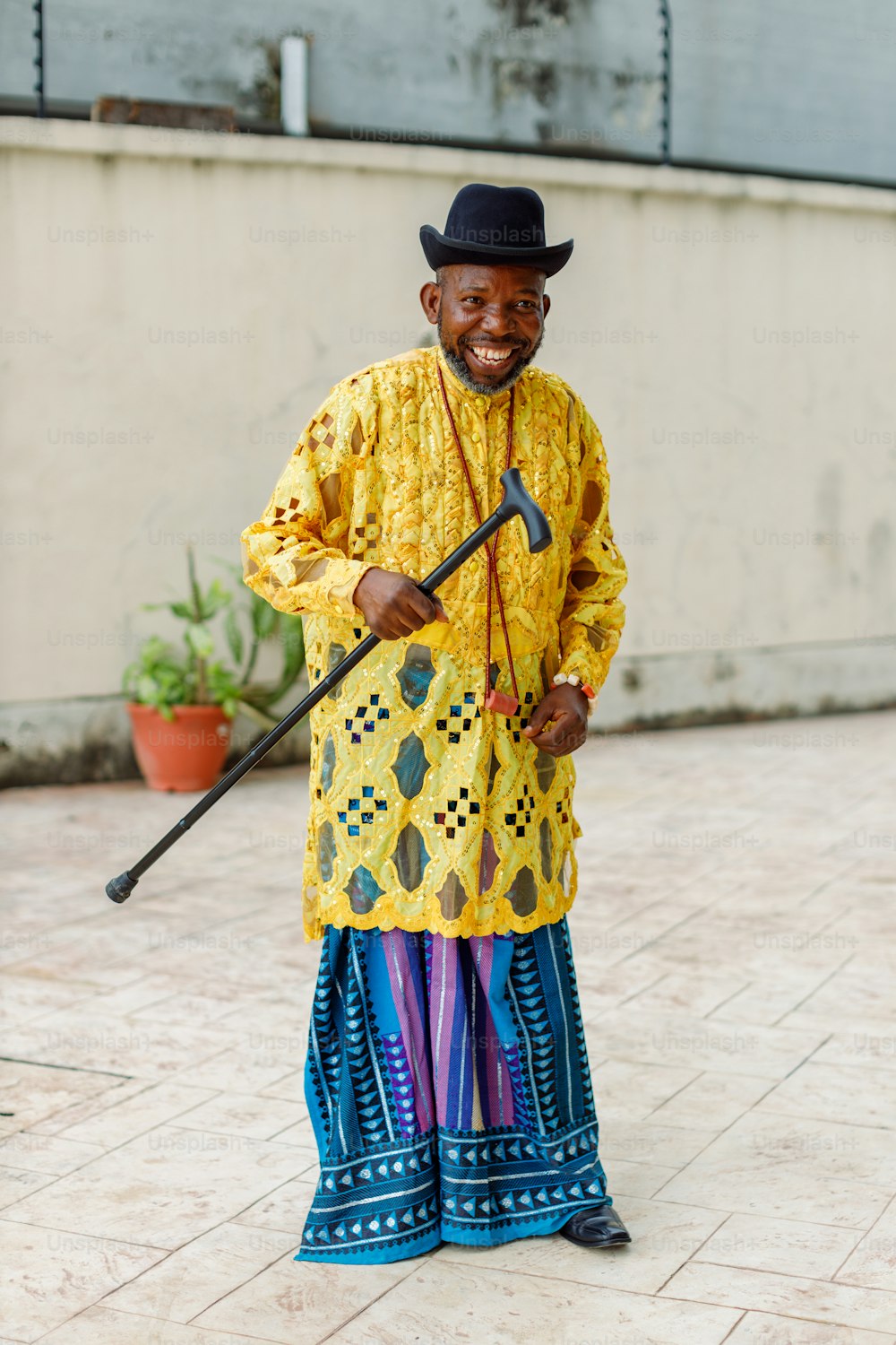 Un homme en tenue jaune et bleue tenant un bâton