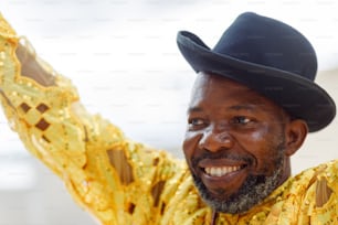 a man wearing a black hat and yellow shirt