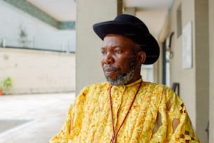 a man wearing a yellow shirt and a black hat