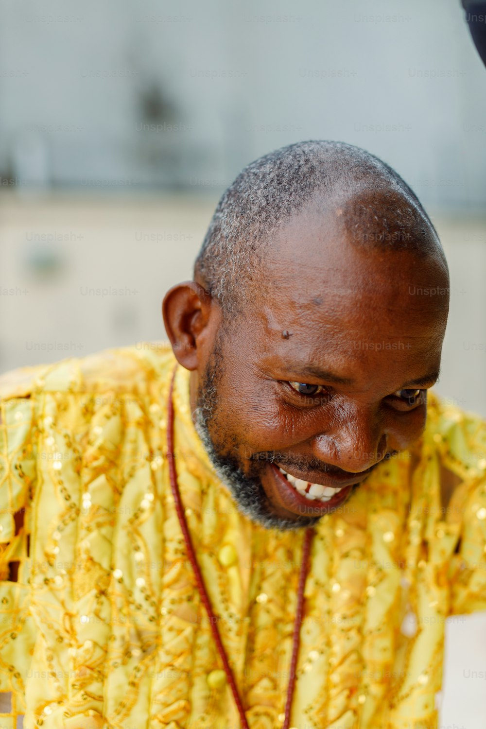 a man in a yellow shirt smiles at the camera