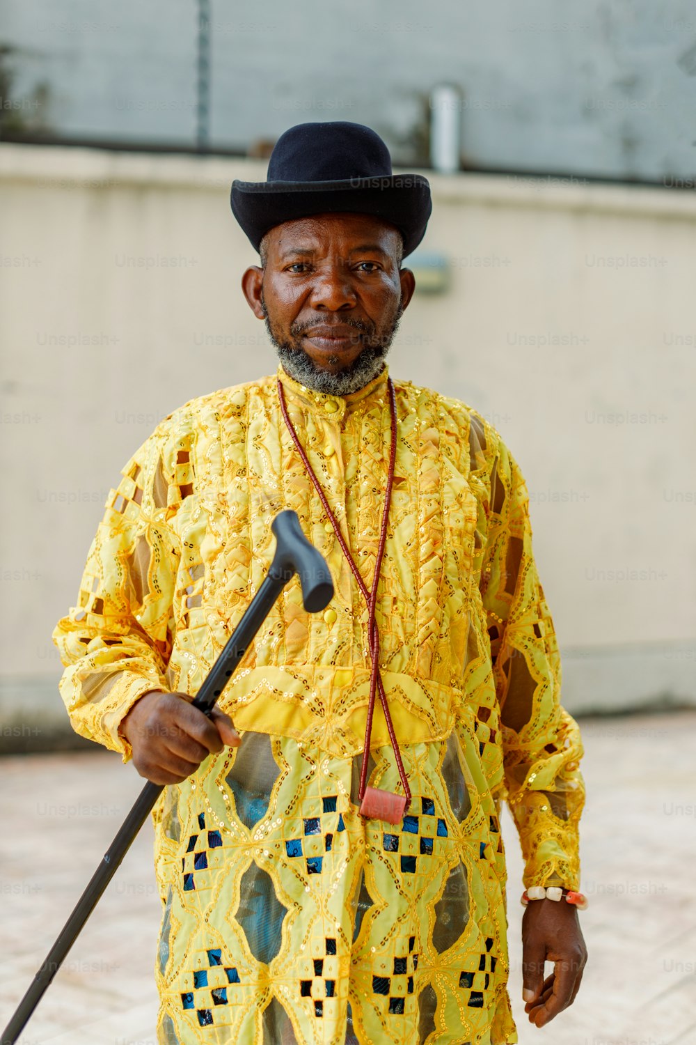 a man in a yellow outfit holding a cane