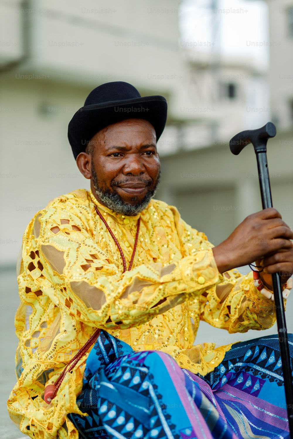 a man sitting on the ground with a cane