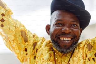 a man wearing a yellow shirt and a black hat