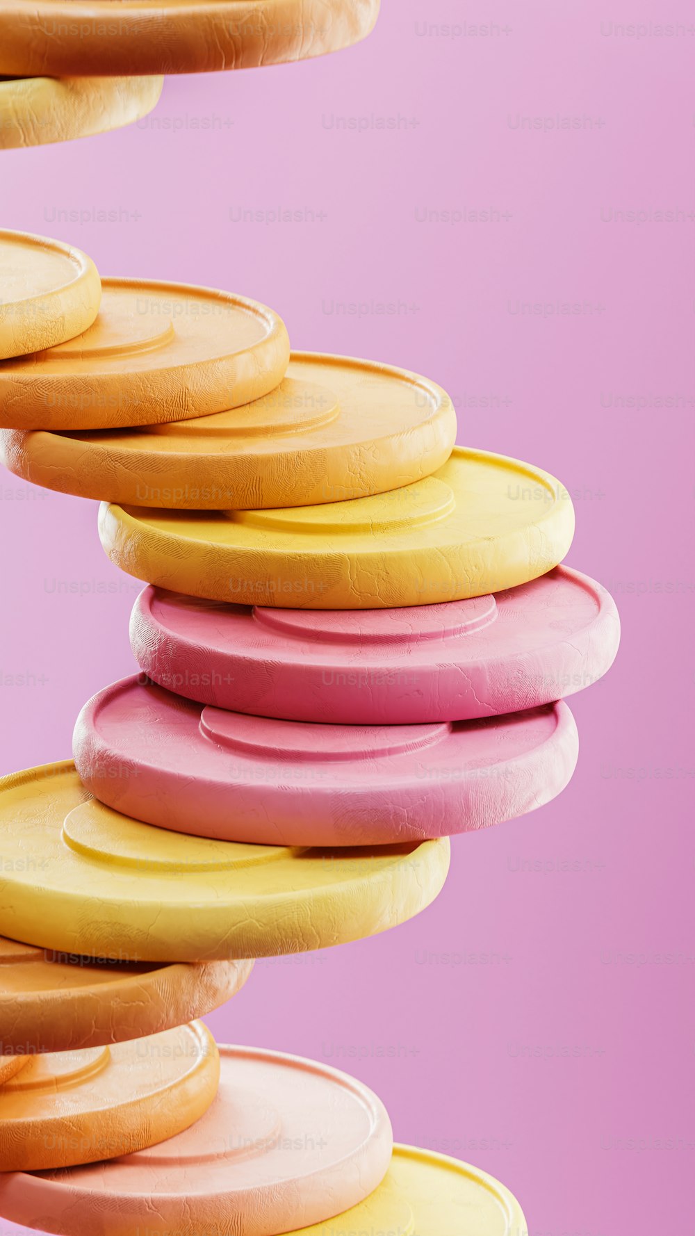 a stack of pink and yellow donuts on a pink background