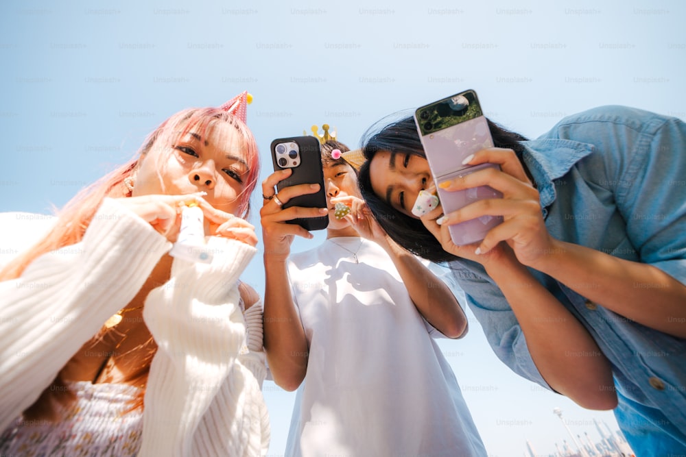 Un groupe de femmes prenant des photos avec leur téléphone portable