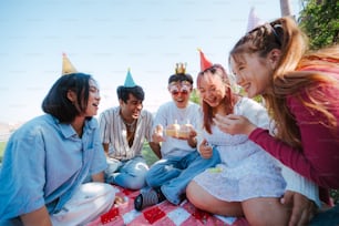 a group of people sitting around a table with cake