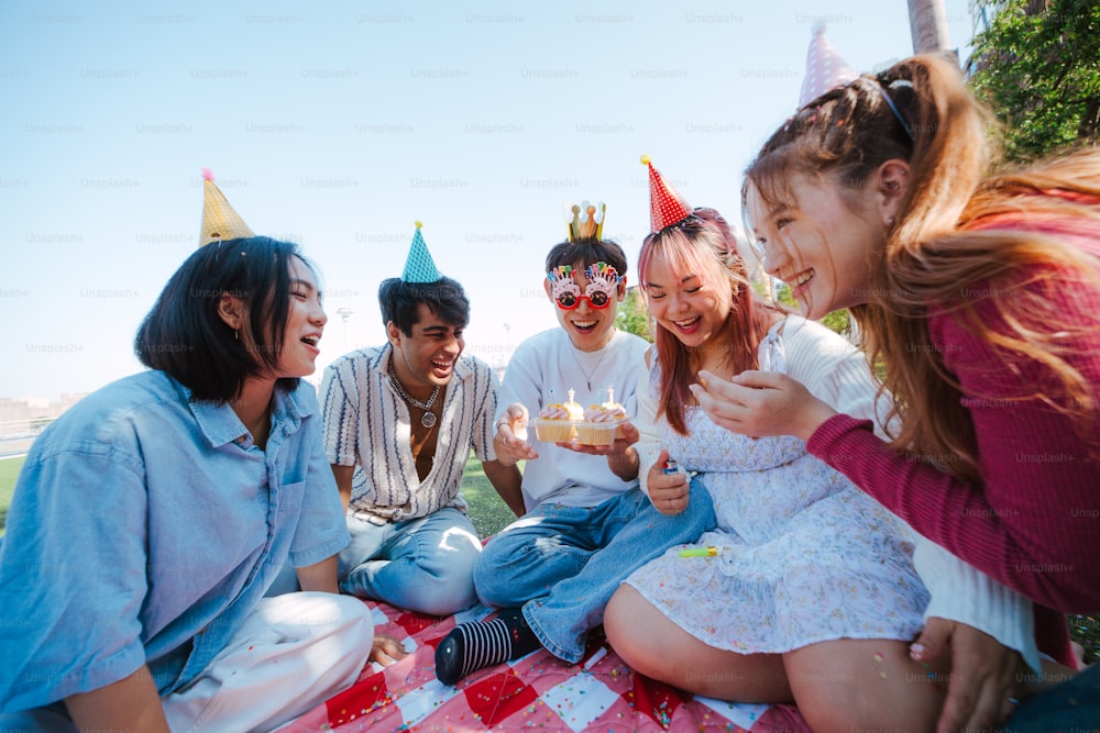 a group of people sitting around a table with cake