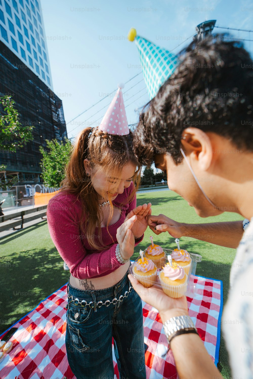 um homem e uma mulher em frente a uma mesa com cupcakes