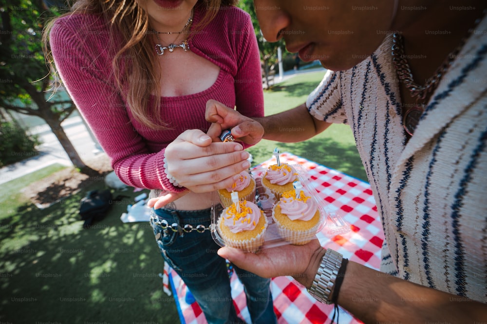 a couple of people that are holding some cupcakes