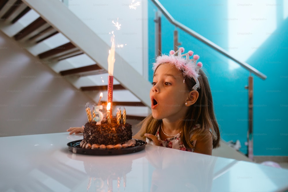 a little girl blowing out a candle on a cake