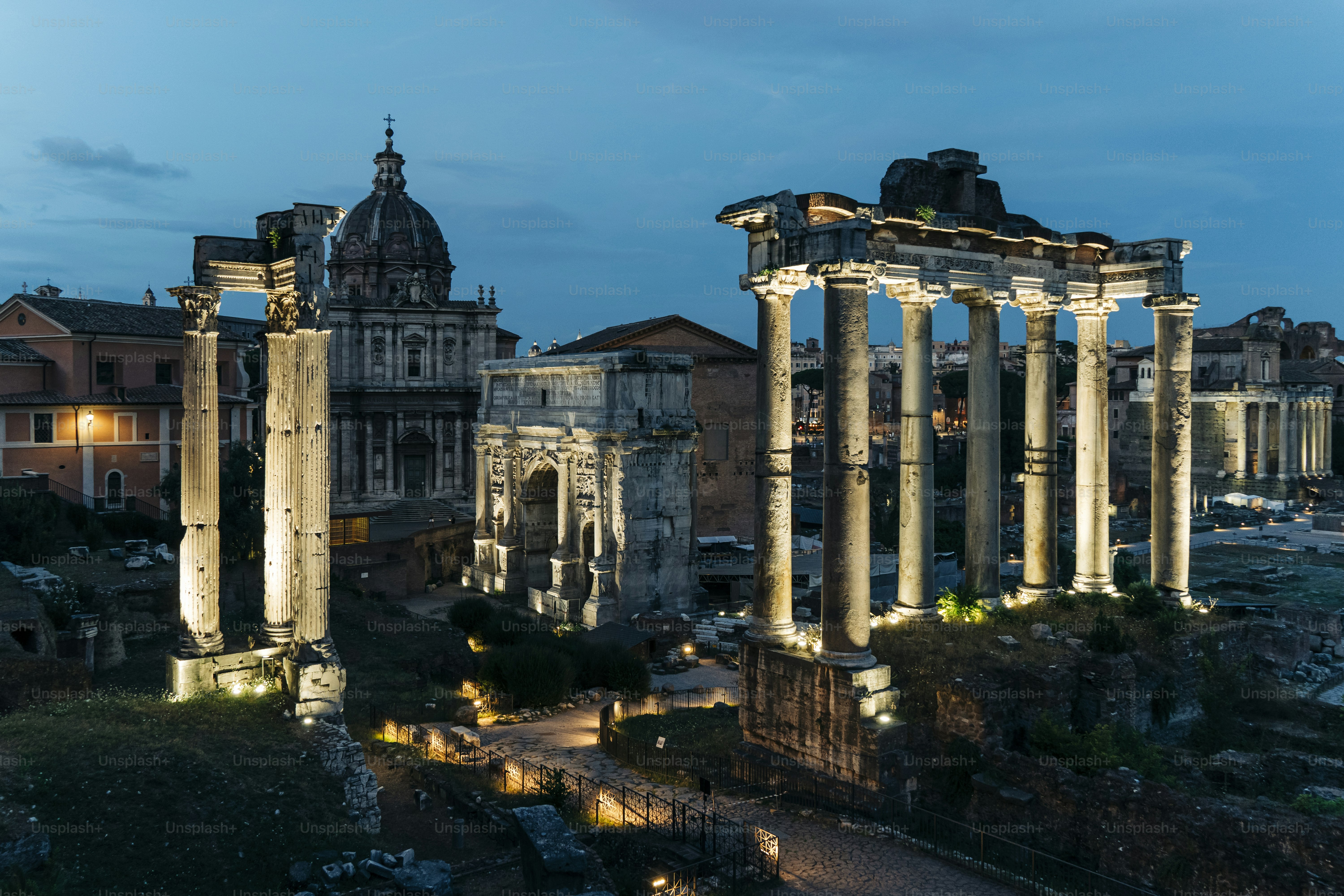 A blue hour view of the Roman Forum with the Temple of Saturn, Arch of Septimius Severus and Temple of Vespasian and Titus, Rome, Italy